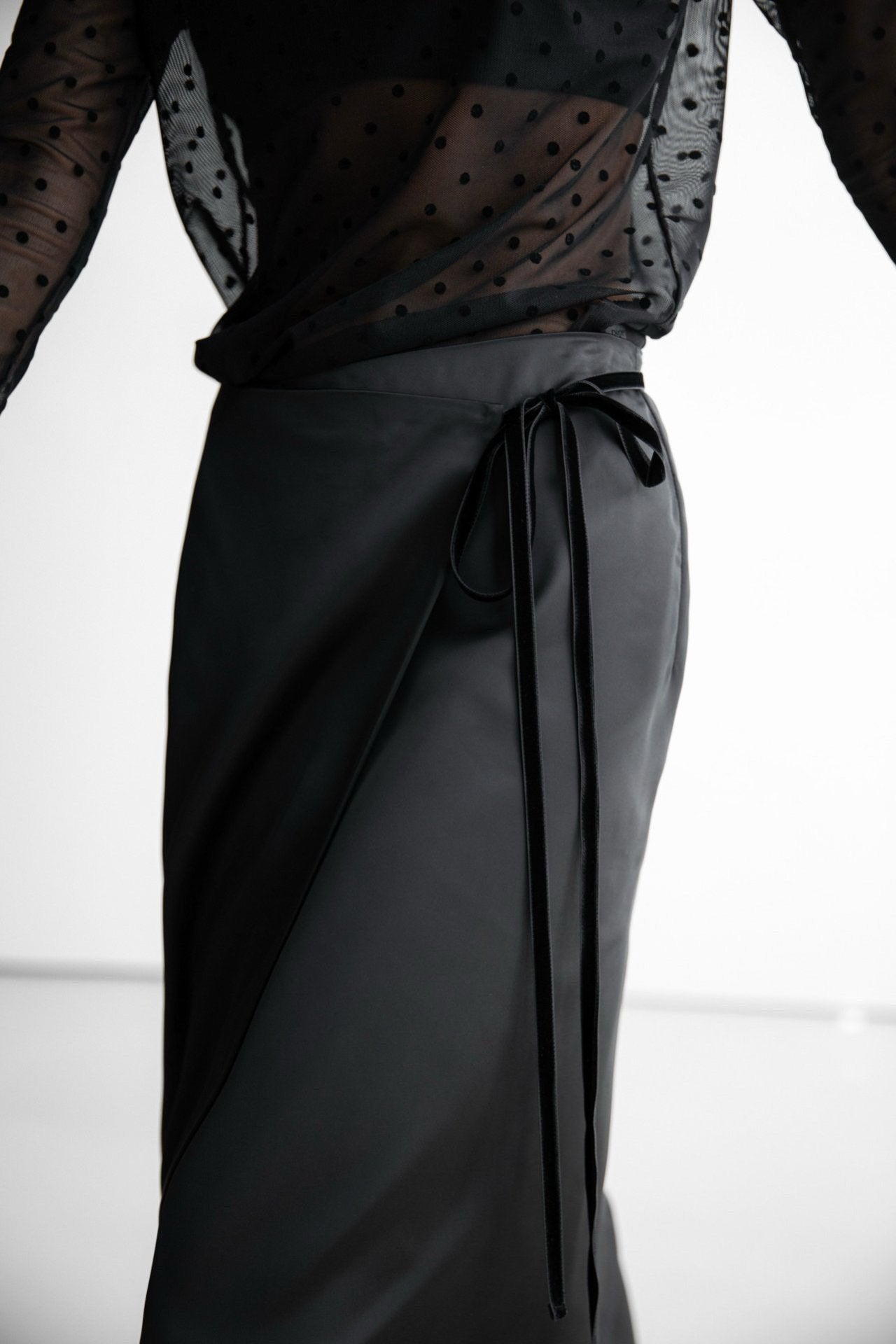 Close-up of black wrap skirt waistband with long tie detail