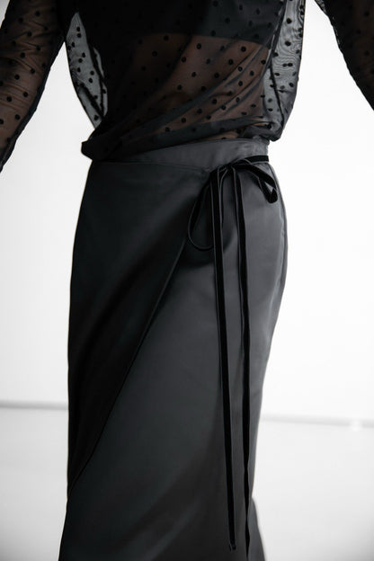 Close-up of black wrap skirt waistband with long tie detail