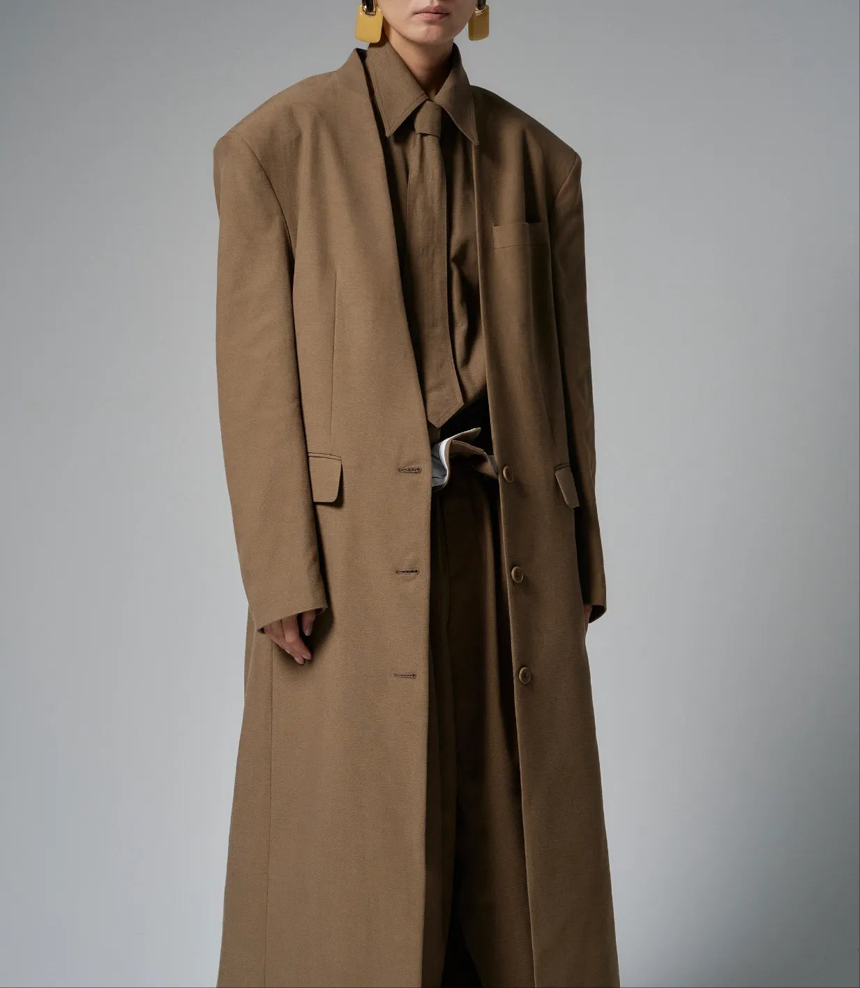 Model wearing the Novaro oversized beige maxi coat with strong shoulders and tailored drape.