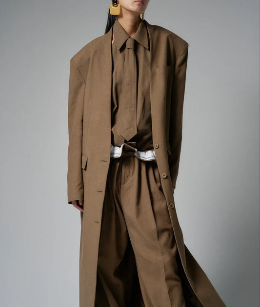 Model wearing a beige tie-front halter shirt styled with wide trousers, showcasing the open-side silhouette.