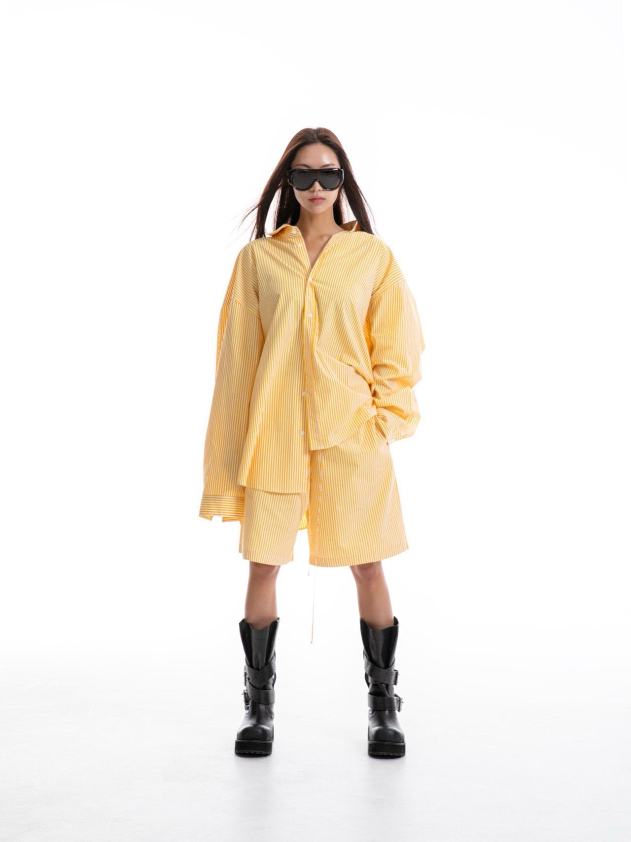 Full-body view of model in yellow striped co-ord set, featuring wide-leg shorts and oversized shirt.