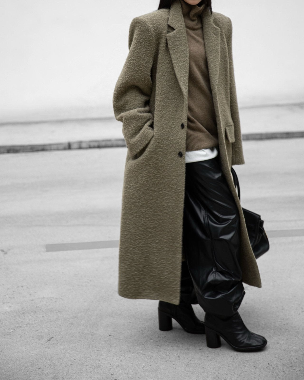 Model wearing oversized khaki beige alpaca-wool bouclé maxi coat styled with leather pants – full front view