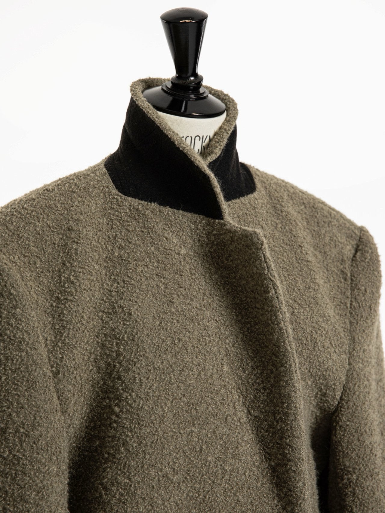 Editorial close-up of the oversized alpaca wool coat’s collar, revealing contrast inner neckline and rich bouclé texture
