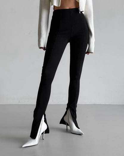 Full-length view of black ribbed leggings with front seam and side slits styled with white top.