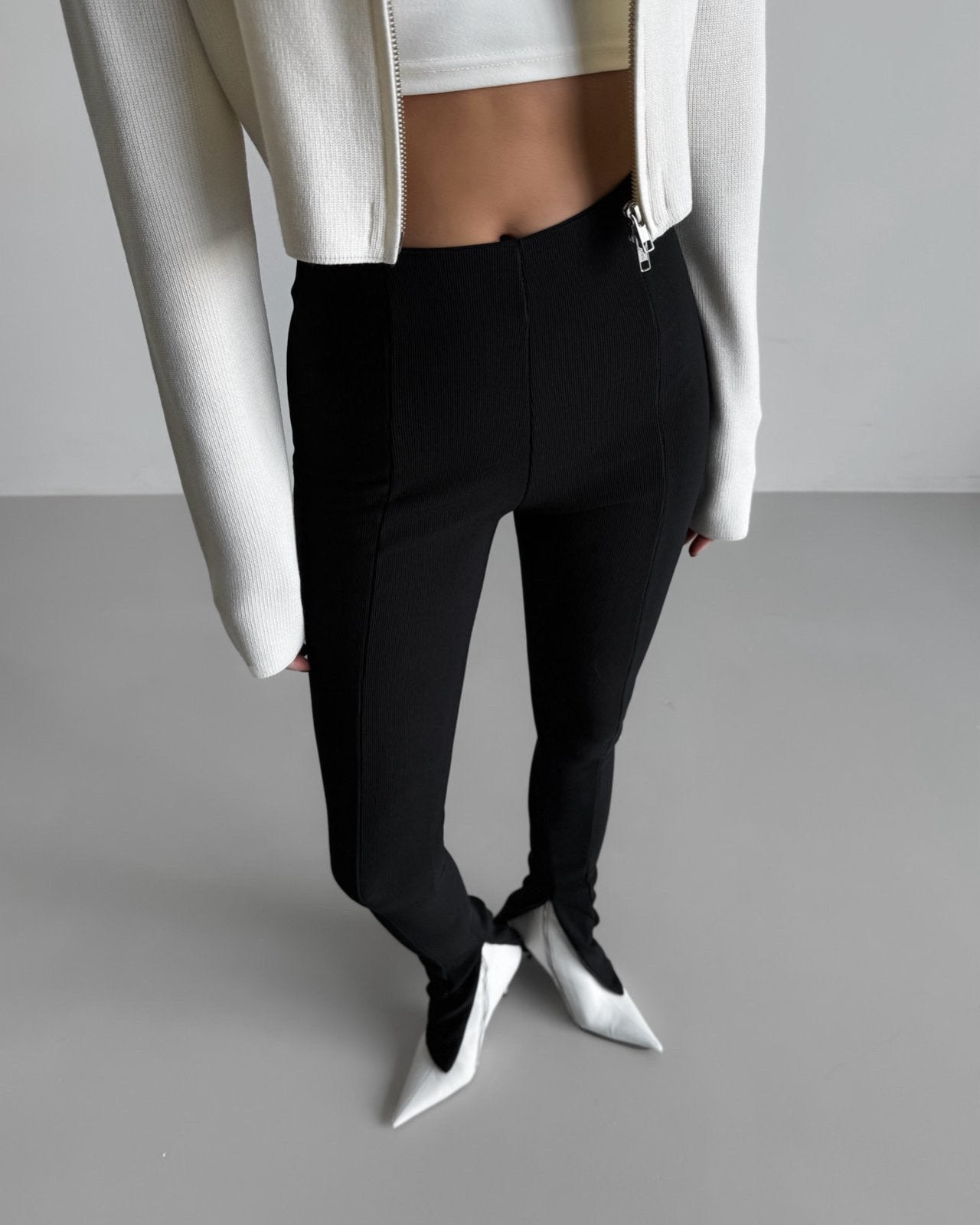 Structured ribbed black leggings styled with cropped white jacket -minimalist front close-up