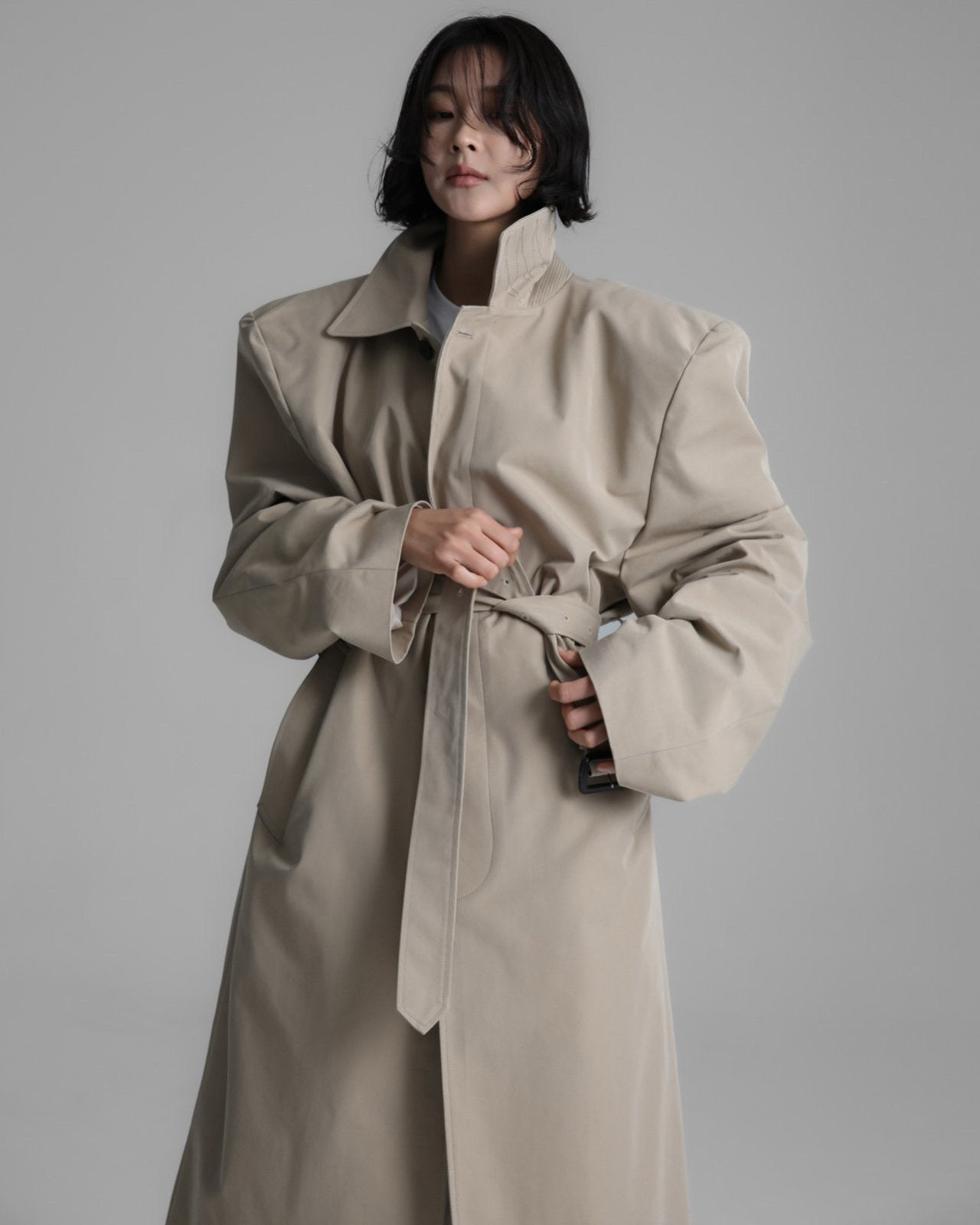 Model wearing the Classic Oversized Structured Trench Coat in beige, showcasing its defined shoulders and elongated silhouette.
