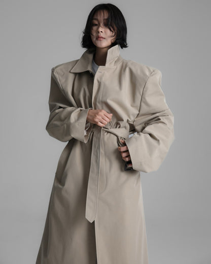 Model wearing the Classic Oversized Structured Trench Coat in beige, showcasing its defined shoulders and elongated silhouette.