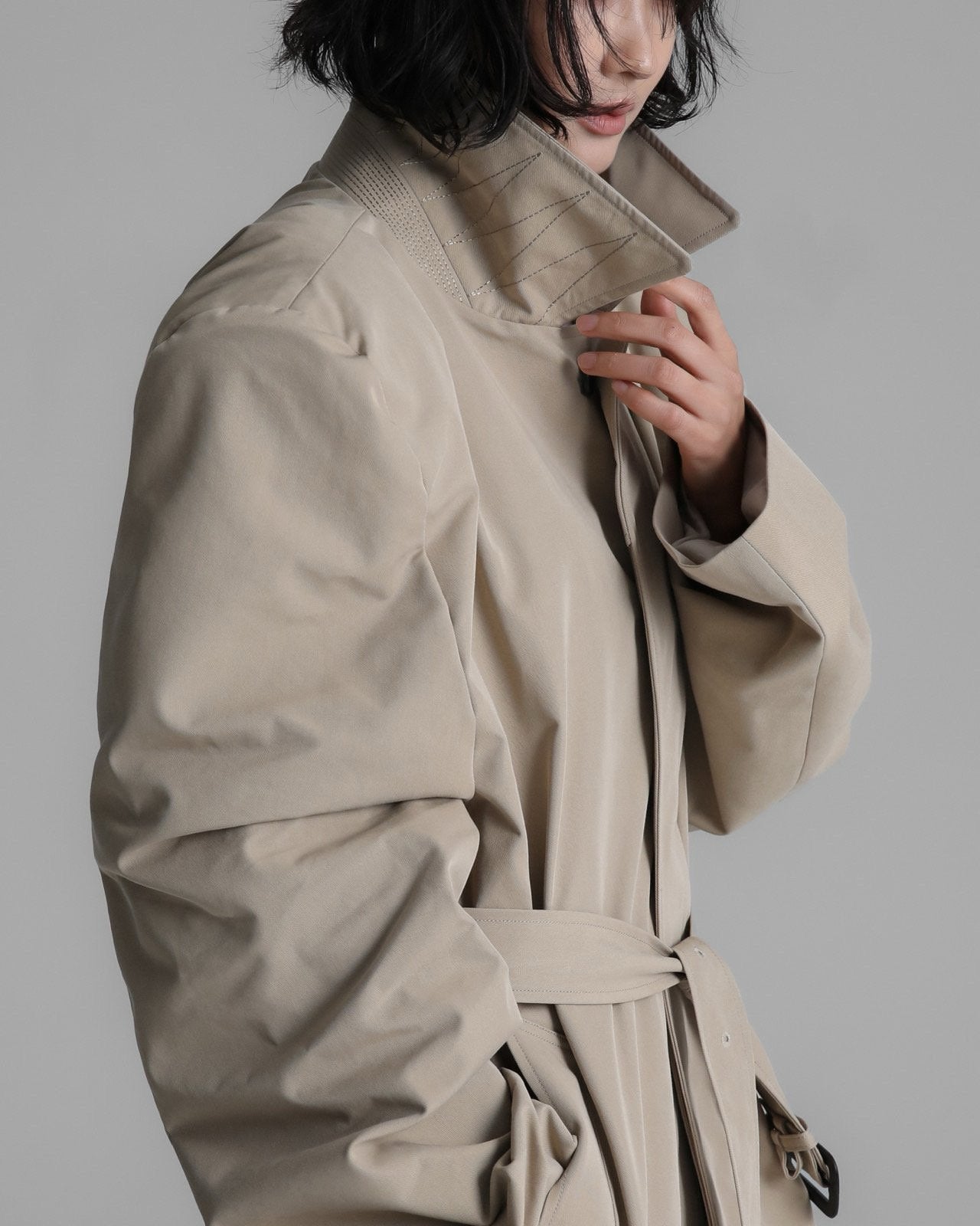 Close-up of the trench coat’s high structured collar and clean stitching detail.