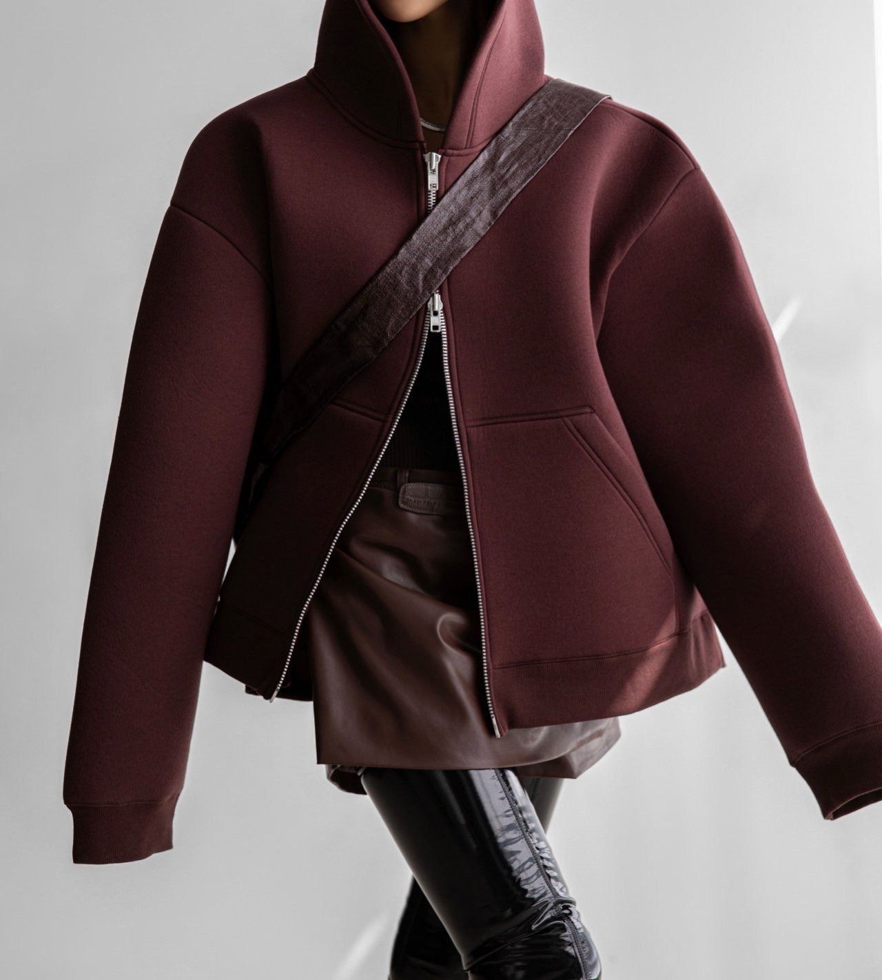 Front view of burgundy neoprene zip hoodie showing oversized fit and clean lines