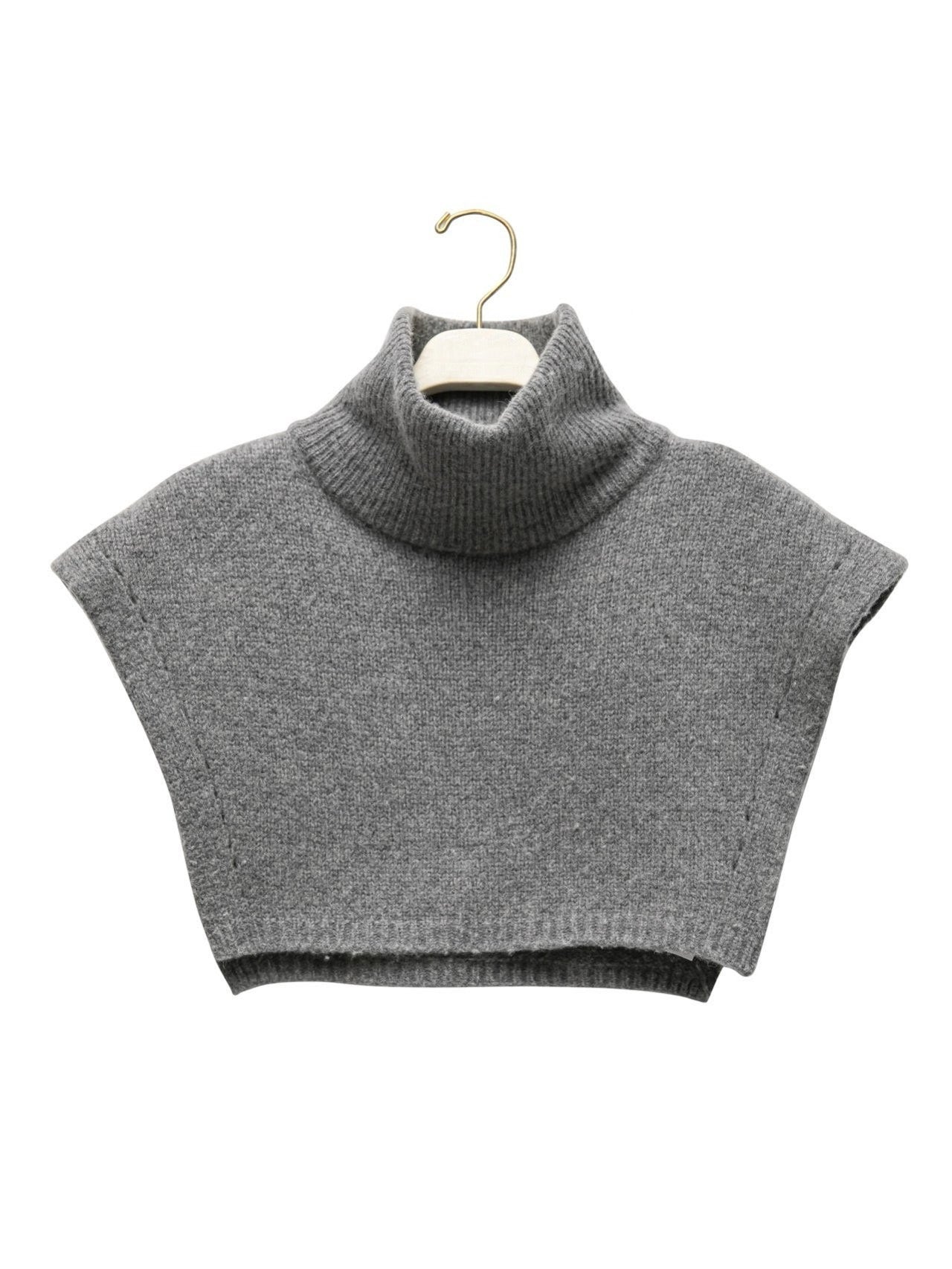 Turtleneck Wool Cape Knit displayed on hanger to show structure and form.
