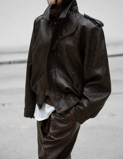 Side view showing relaxed oversized fit of brown vegan leather bomber jacket