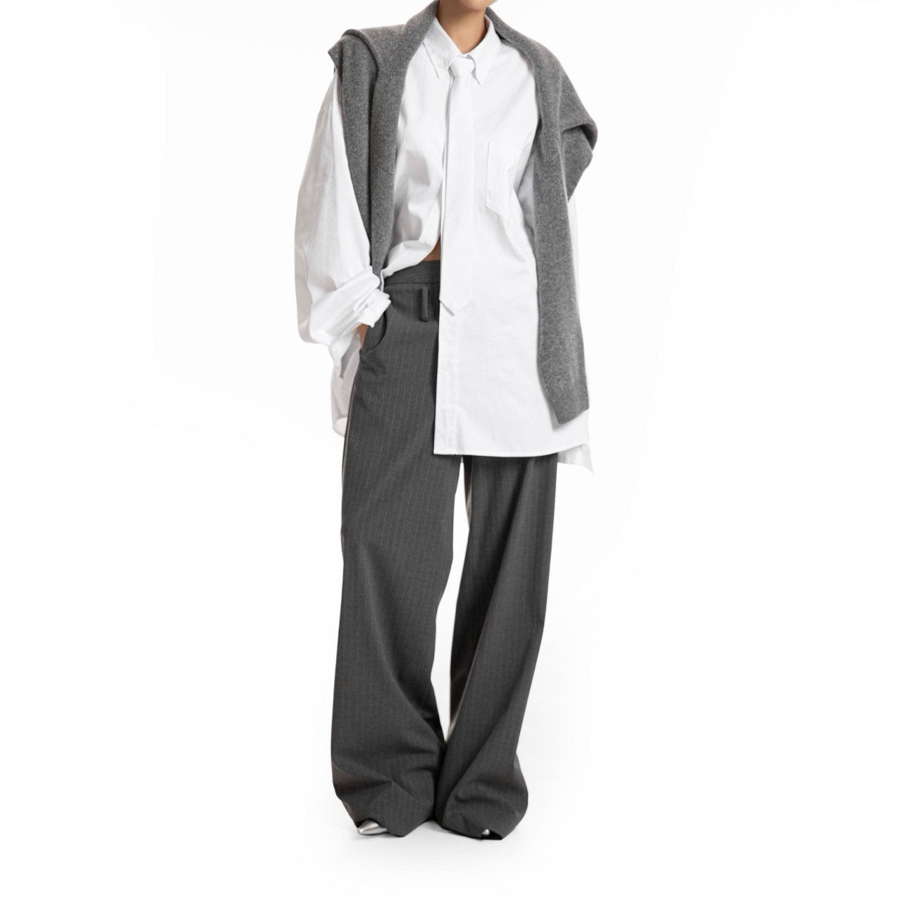 Full look featuring oversized white shirt styled with gray sweater and wide-leg trousers — effortless urban minimalism.