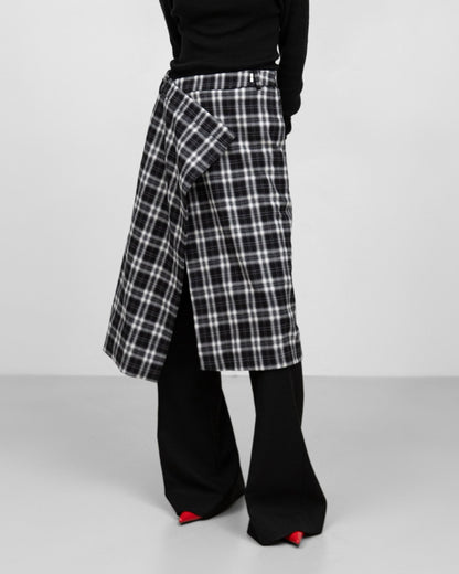 Side view of black-and-white plaid wrap midi skirt showing wrap detail.