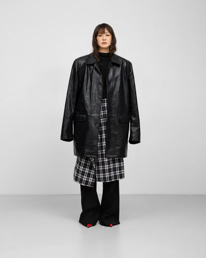Editorial full-body look with plaid wrap midi skirt and black knit top. and leather patchwork structured half coat