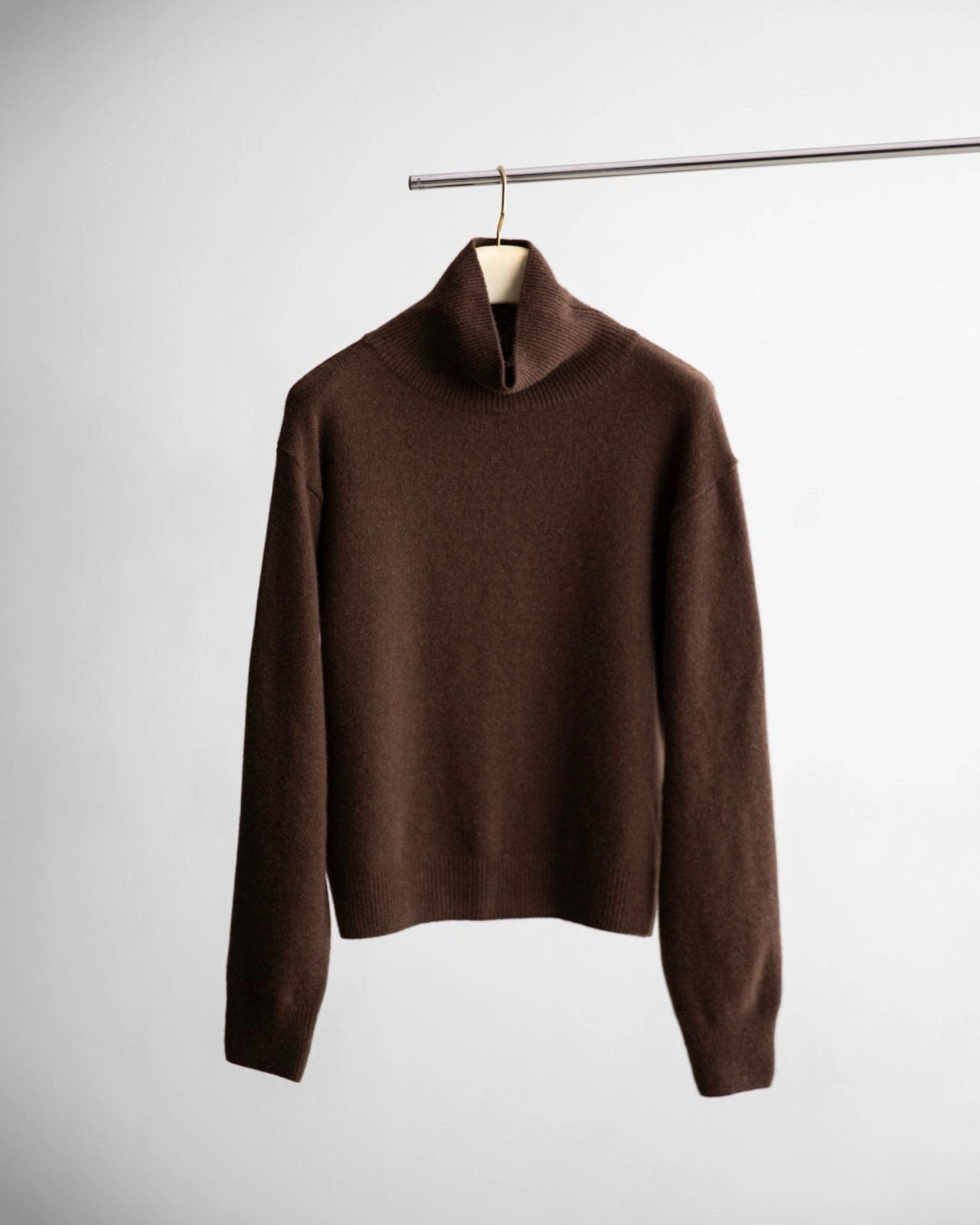 Chocolate brown cashmere-blend high neck sweater hanging on minimalist rack – CONTOUR New York
